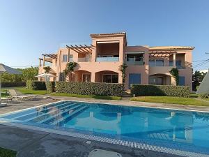 a villa with a swimming pool in front of a house at Apartment Odysea in Platanias