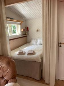 a small bedroom with a bed with a window at LillaStugan in Jönköping