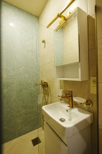 a bathroom with a sink and a glass shower at Casa Camellia in Kobuleti