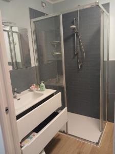a bathroom with a sink and a shower with a glass door at Dolce Luna in Gargnano