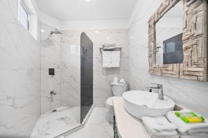 a white bathroom with a sink and a shower at Buena Vista Plus in Quepos +63 photos