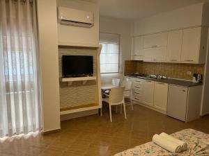 a kitchen with a table and a television in a room at Amras house in Durrës