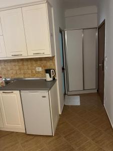 a kitchen with white cabinets and a refrigerator at Amras house in Durrës