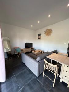 a living room with a couch and a table at Petite maison Dépendance SOUSTONS in Soustons