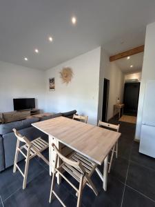 a dining room with a wooden table and chairs at Petite maison Dépendance SOUSTONS in Soustons