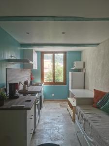 a kitchen with a couch in the middle of a room at Maison Romana in Riez