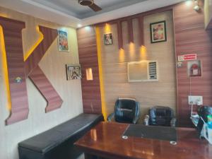 a waiting room with a desk and two chairs at Hotel Shivay in Haridwār