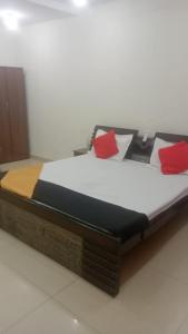 a bed in a room with red pillows on it at Hotel Shivay in Haridwār
