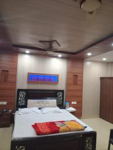 a bedroom with a large bed with a blue window at Hotel Shivay in Haridwār