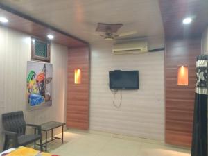 a room with a wall with a tv and a table at Hotel Shivay in Haridwār