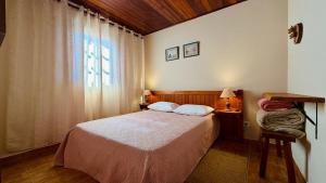 a small bedroom with a bed and a window at Recanto Luar Monte Verde in Monte Verde