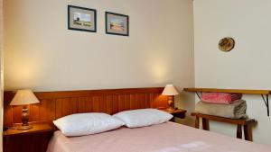 a bedroom with a bed with two lamps and two pillows at Recanto Luar Monte Verde in Monte Verde