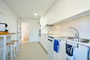 a kitchen with white cabinets and a sink at Sun&Fun Villa in Vinarós