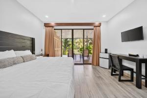 a bedroom with a bed and a desk and a television at Buena Vista Plus in Quepos