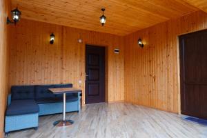 a room with a couch and a table and a door at Sky Glass Cottage in Kʼveda Chʼkhutunetʼi