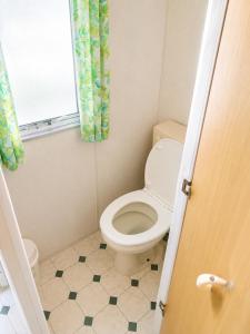 a small bathroom with a toilet and a window at Chatka w środku lasu in Czerwona Wola +12 photos