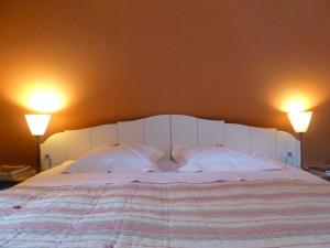 1 cama con 2 almohadas y 2 luces en la pared en Chambre d'Hôtes Les Augustins - Parking sécurisé - Borne de recharge en Huy