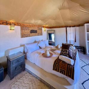 a bedroom with a large bed in a tent at Erg Chigaga Luxury Camp in El Gouera