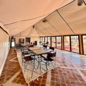 a tent with tables and chairs in a room at Erg Chigaga Luxury Camp in El Gouera +47 photos