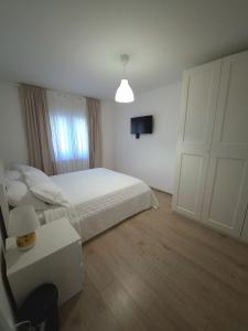 a bedroom with a white bed and a white door at Rina Apartment- with barbecue and free parking in Kaštela