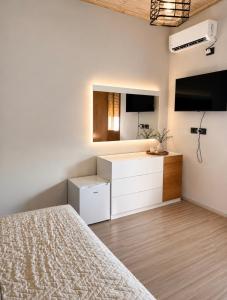 a bedroom with a bed and a dresser and a tv at Versailles Rooms in Dukati i Ri