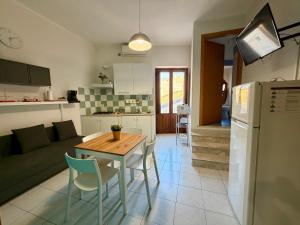a kitchen and living room with a table and a couch at TESEO Siracusa in Ortigia fuori dalla ZTL in Syracuse +17 photos