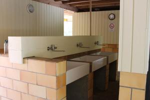 a bathroom with three sinks in a room at Camping Le Capdeville in Carcans
