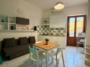 a kitchen and living room with a table and a couch at TESEO Siracusa in Ortigia fuori dalla ZTL in Syracuse