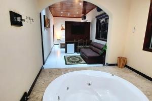 a living room with a large white tub in a room at Hotel Gran Minas in Vespasiano