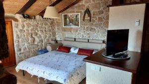 a bedroom with a bed and a desk with a television at El Racó de les Grases in Horta de San Joan