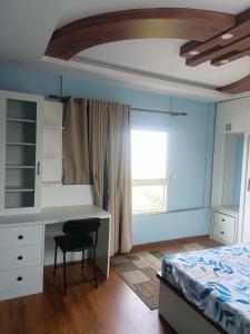 a bedroom with a bed and a desk and a window at Le Petit Paradis Nepal Terrace & Mountain View in Pātan