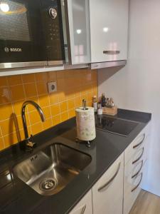 a kitchen with a sink and a microwave at Muralha da Barca Apartamentos -Fique no centro do Porto junto a ponte D-Luis IRNAL nº13939 Al,5848 Al, 6419 AL-Chamada para a rede móvel nacional in Porto