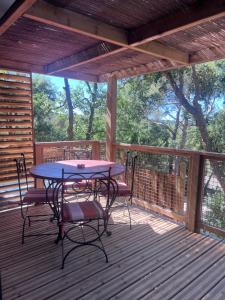 a patio with a table and chairs on a deck at Chalet Cannelle Spa camping Buffalo Hacienda in La Seyne-sur-Mer