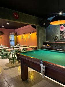a pool table in a restaurant with tables at Caiçara Guest House in Ubatuba