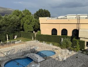 a building with two swimming pools in front of it at Hotel Lux in Mitrovica