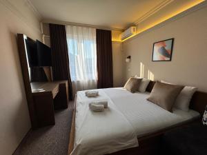 a hotel room with a large bed and a television at Hotel Lux in Mitrovica