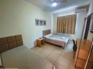 a room with a bed and a bed and a room with a bed at Pousada Pedra Branca in Corinto