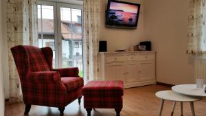 a living room with a chair and a tv on the wall at Villa Hilde in Oy-Mittelberg