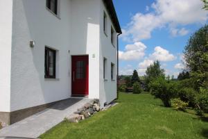 a red door on the side of a white building at Villa Hilde in Oy-Mittelberg