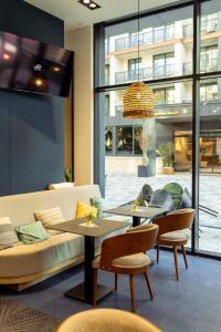 a living room with two tables and a couch at Modena Resort Spa & Wellness Zlatibor in Zlatibor