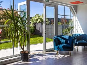 a room with two blue chairs and a potted plant at ibis budget Strasbourg Sud Illkirch in Geispolsheim