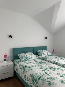 a bedroom with a bed with a green headboard at Apartmani Stevanović in Zvornik