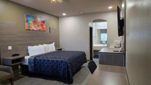 a hotel room with a bed and a desk at Lone Star Inn - San Benito Los Indios in San Benito