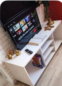 a white desk with a tv on top of it at Comfortable Apartment Near Alphaville in Jandira