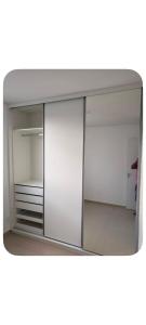 a large white closet with a glass door at Comfortable Apartment Near Alphaville in Jandira