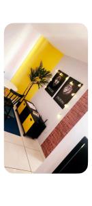 a room with a palm tree and a yellow wall at Comfortable Apartment Near Alphaville in Jandira