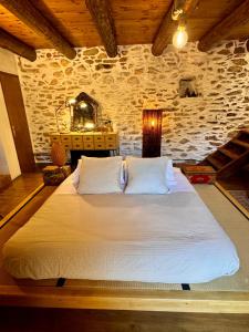 a large bed in a room with a stone wall at Cal David Estamariu in Estamariu +63 photos