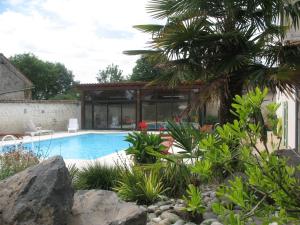 a swimming pool in a garden with a house at Bellevue in Châteaubernard