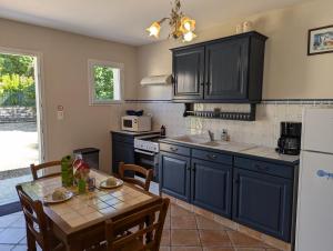 a kitchen with dark blue cabinets and a table with a tableablish at Bellevue in Châteaubernard
