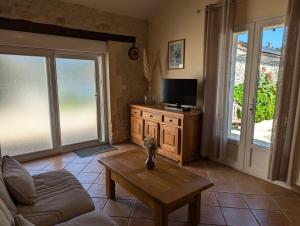 a living room with a couch and a tv and a table at Bellevue in Châteaubernard